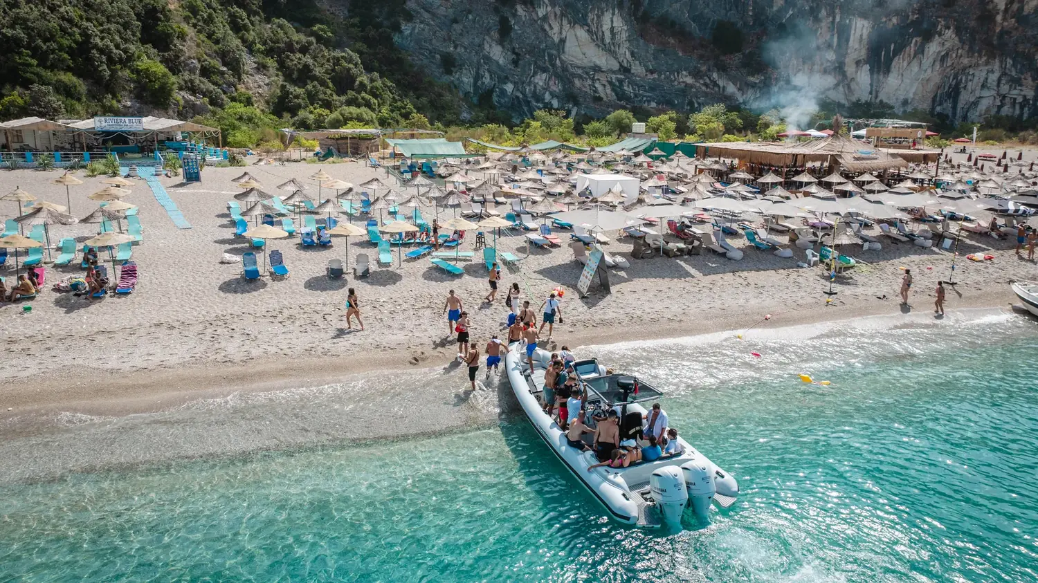 The Beast Boat coming in to a beach lined with sun loungers near Saranda
