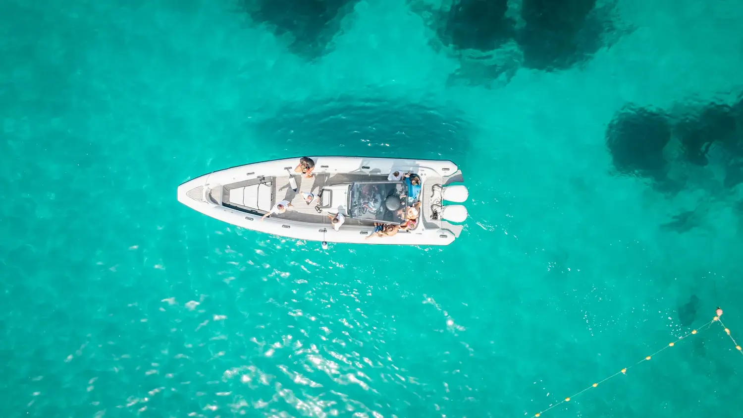 Top-down drone view of the Beast Boat in clear turquoise water